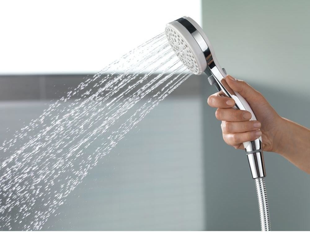 A hand holding the showerhead