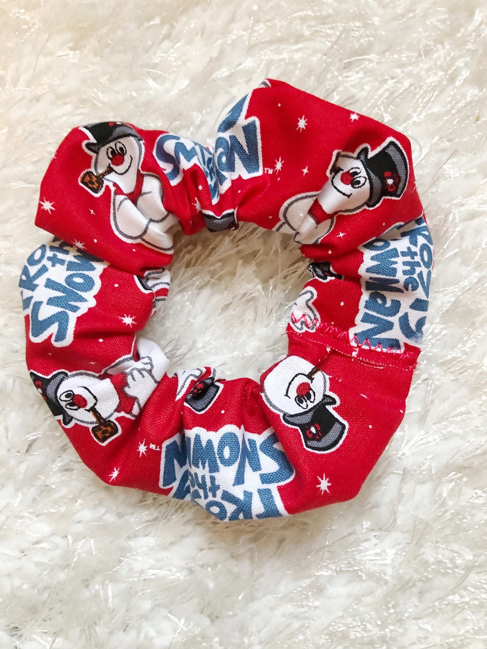 a red scrunchie with frosty on it