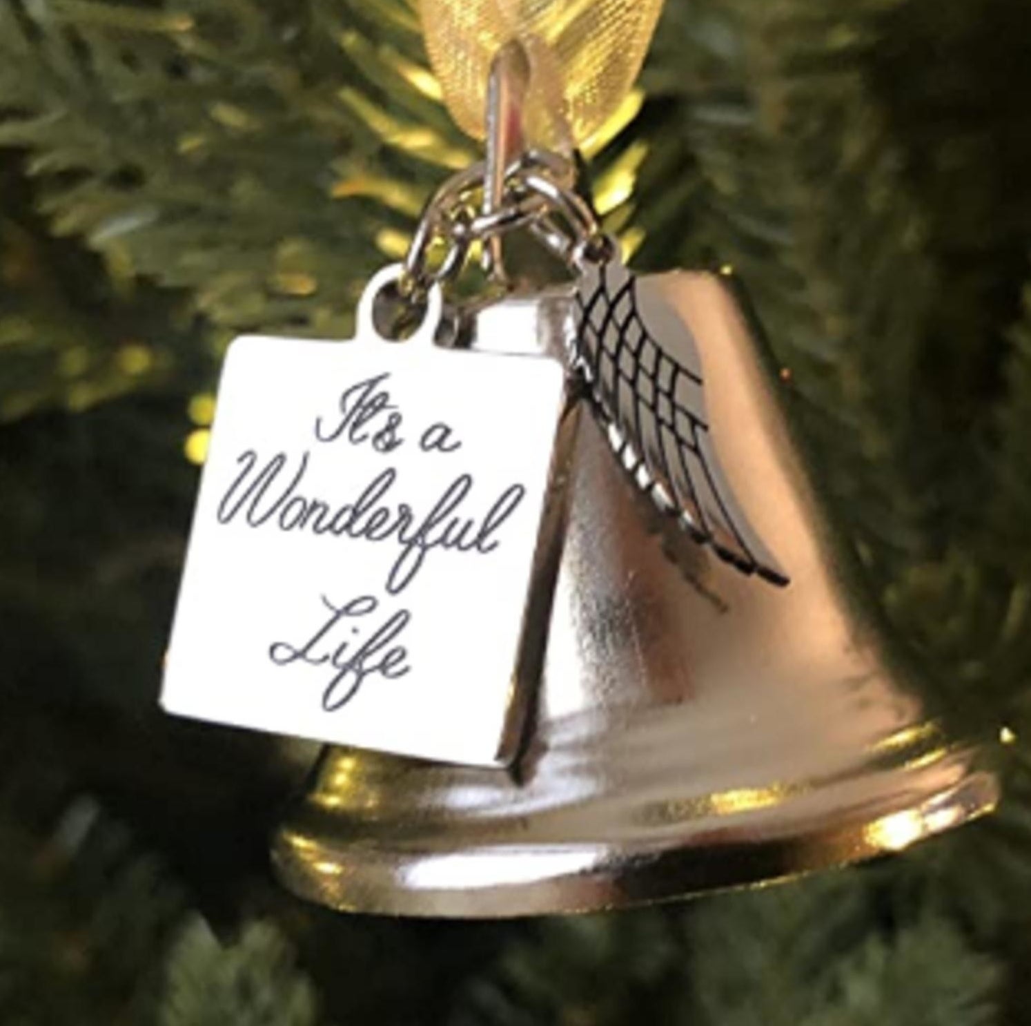a bell with an angel wing on it and a charm that says &quot;it&#x27;s a wonderful life&quot;