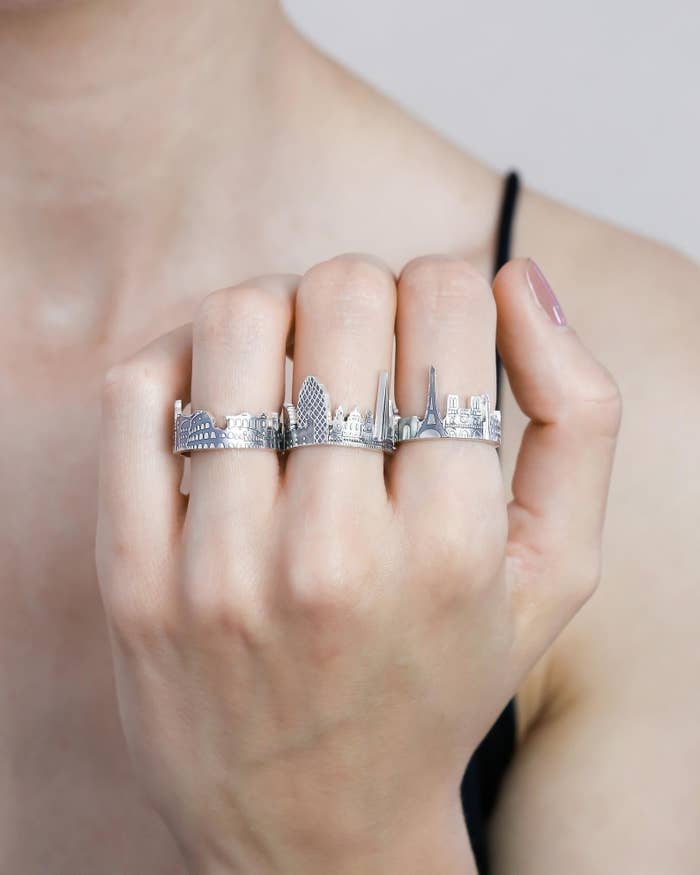 model wearing silver ring with cityscape design 