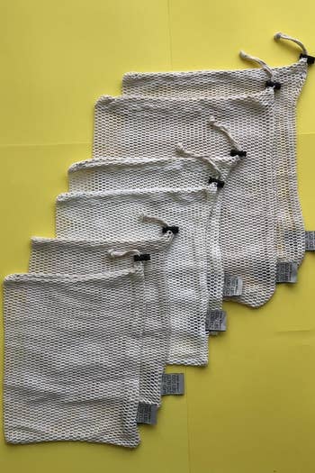 six different-sized reusable mesh produce bags with drawstring closures 