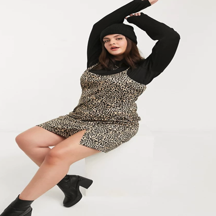 a model in a leopard cami dress with black long sleeves layered underneath 