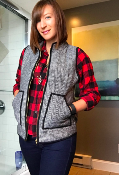 a reviewer wearing the vest with jeans and a plaid shirt 