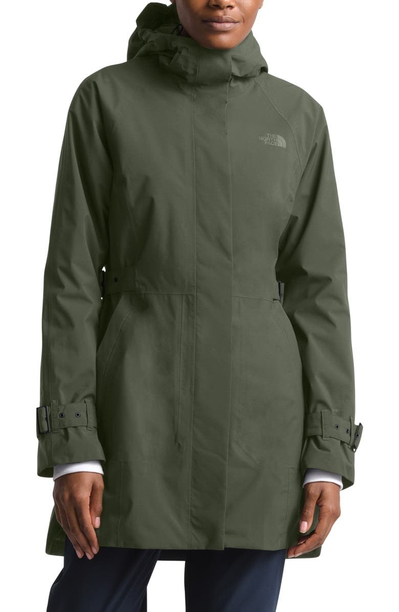 a model wearing the raincoat in taupe green
