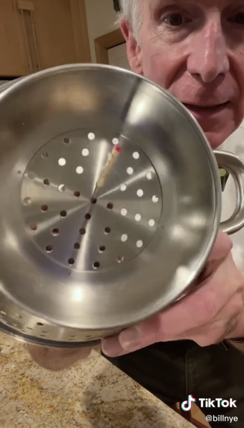 Bill Nye poking a stick through a strainer