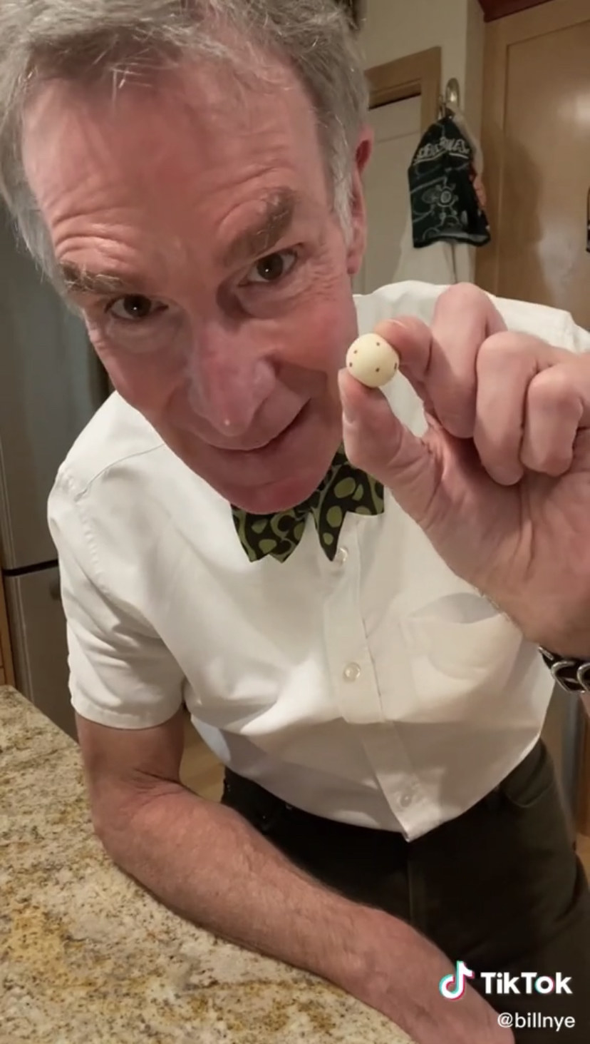 Bill Nye holding up a clay ball meant to represent a spit droplet