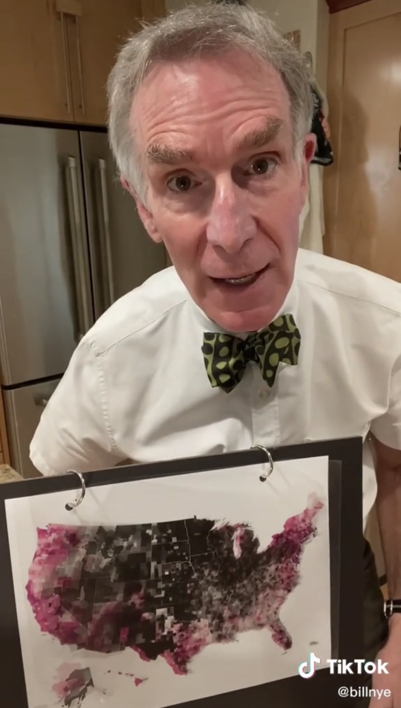 Bill Nye in front of a map with highlighted red and black areas