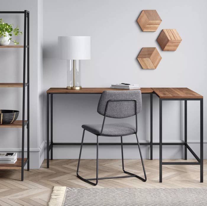 An L-shaped desk with metal frame and wood top