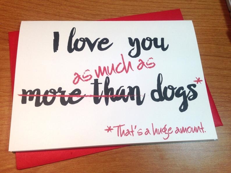 A white card that says "I love you more than dogs" in black, with "more than" crossed out in red, and replaced with "as much as (that's a huge amount"