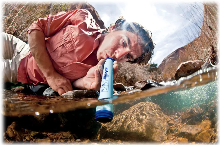 Camper uses blue water filtration device to safely drink water from a stream