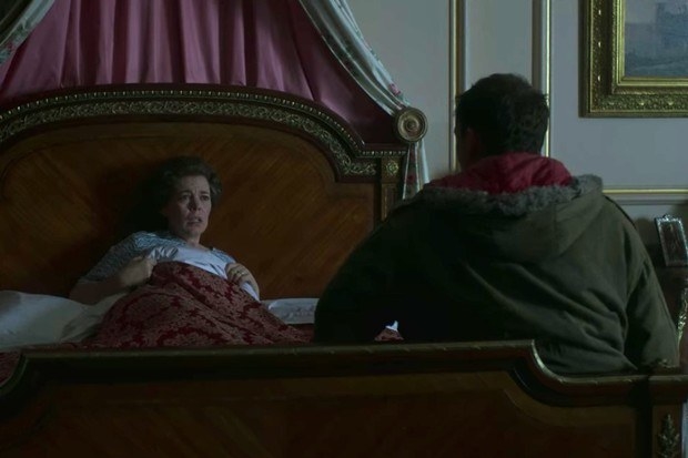 An image of Olivia Colman (Queen Elizabeth) in bed being woken up by her intruder.