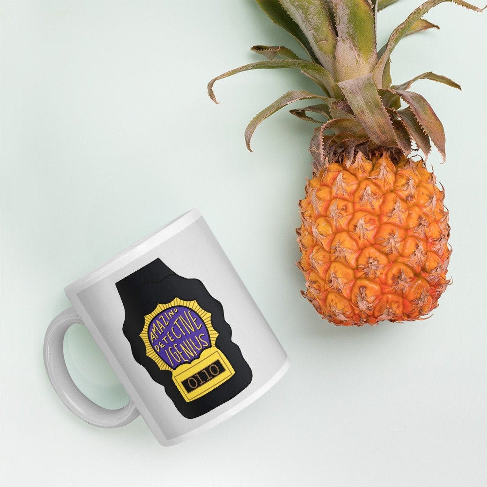 A police badge design on a mug that says &quot;amazing detective slash genius&quot;