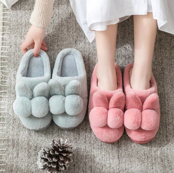 person wearing a pair of slippers and holding a pair