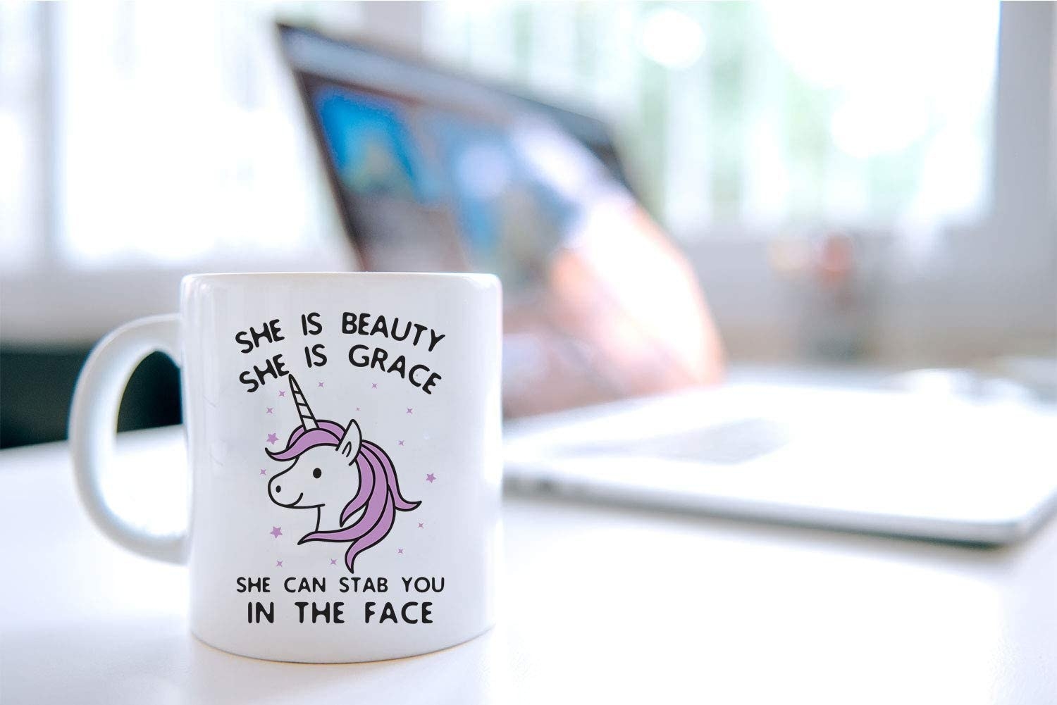 A mug with a unicorn on it that says &quot;she is beauty she is grace she can stab you in the face.&quot;