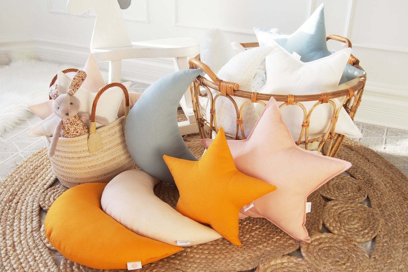 mix of star and moon pillows on a rug and in a basket