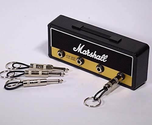 A rectangular key ring holder that looks like a mini guitar amp with four guitar plug keychains