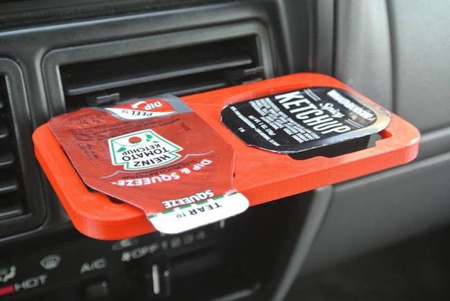 The red dip clip holding Heinz ketchup and Whataburger spicy ketchup