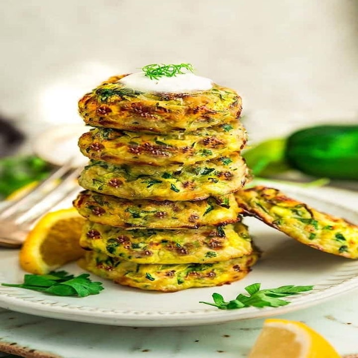 A stack of air fried zucchini fritters on a plate.