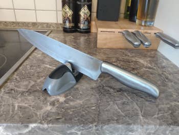 Reviewer photo of a knife propped in the knife sharpener 