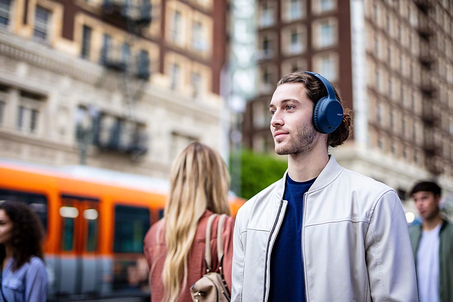 A person walking down the street wear over-ear headphones