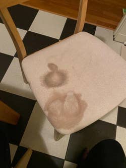 A reviewer's photo which shows a before photo of a chair with a huge stain