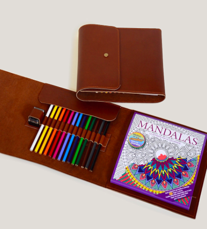 A leather colouring kit unfurled to reveal coloured pencils and a colouring book