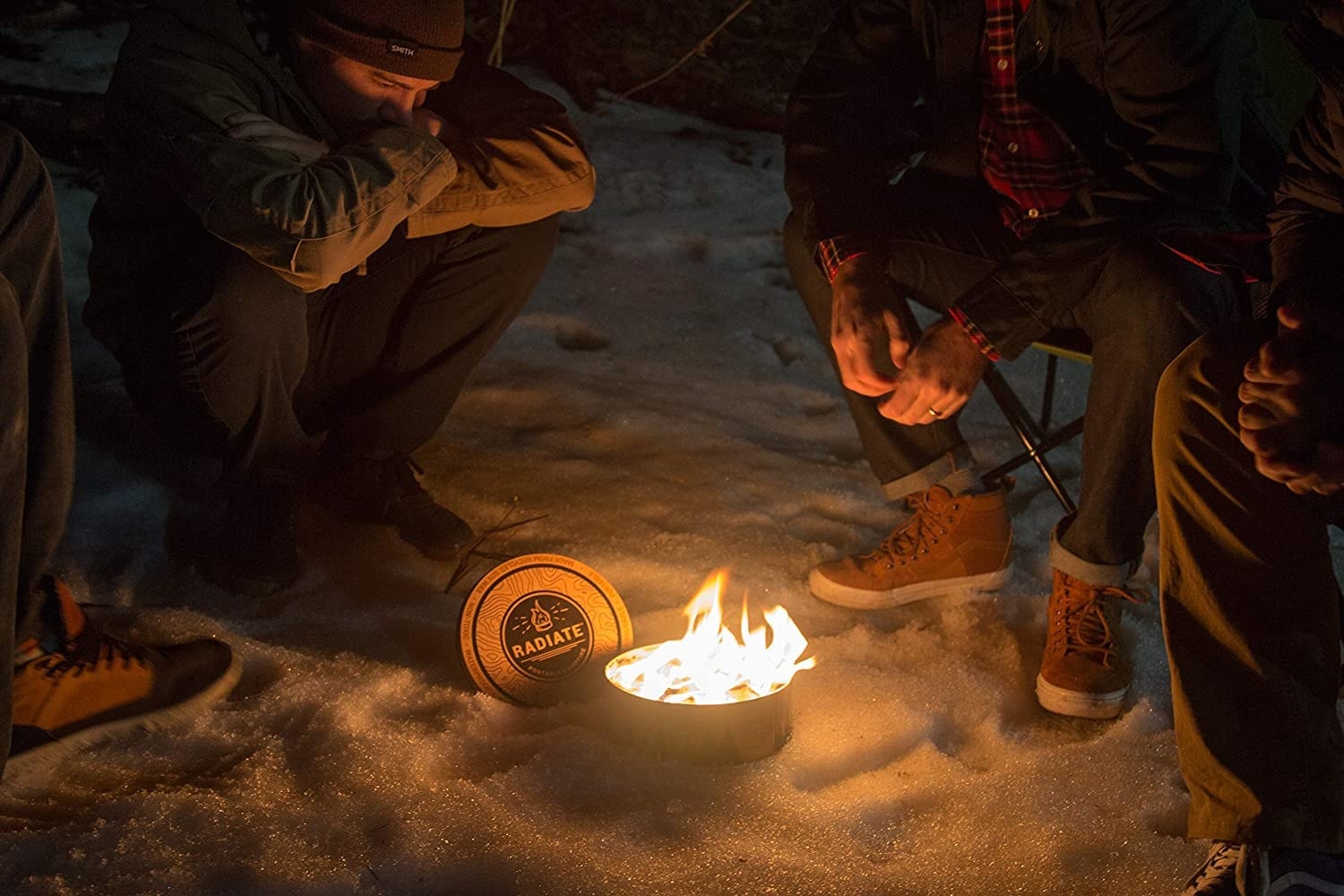 Models sit around a portable campfire