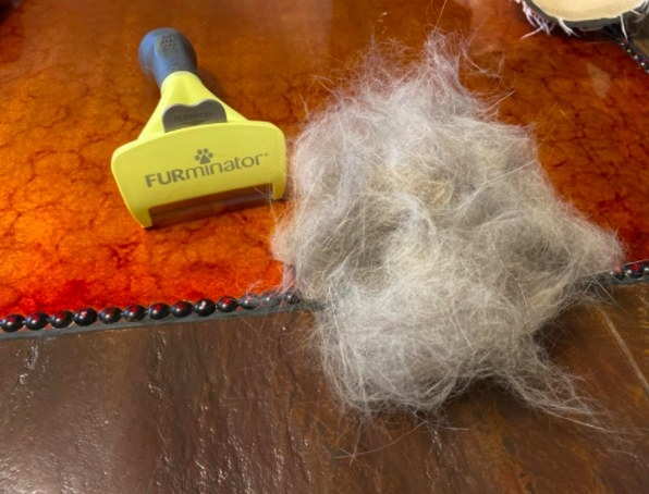 a huge clump of pet hair next to the furminator