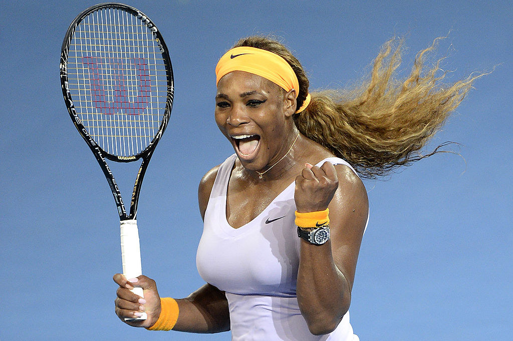 Serena holding a tennis racket and her fist up