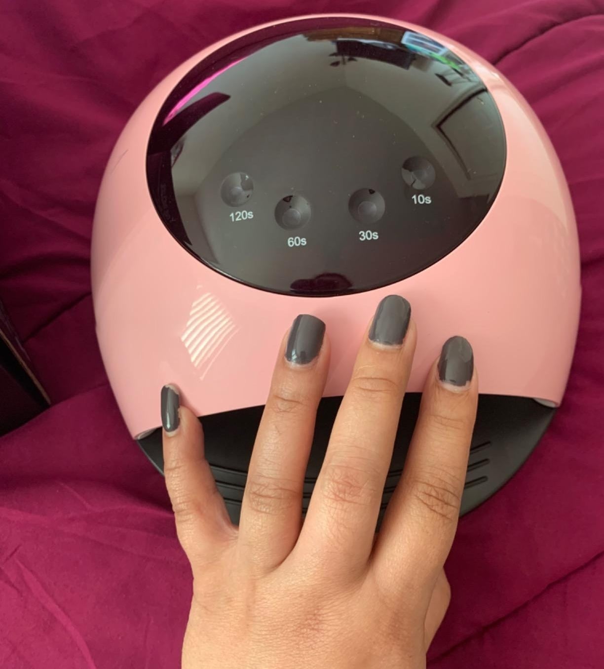 Freshly done nails placed on top of drying lamp