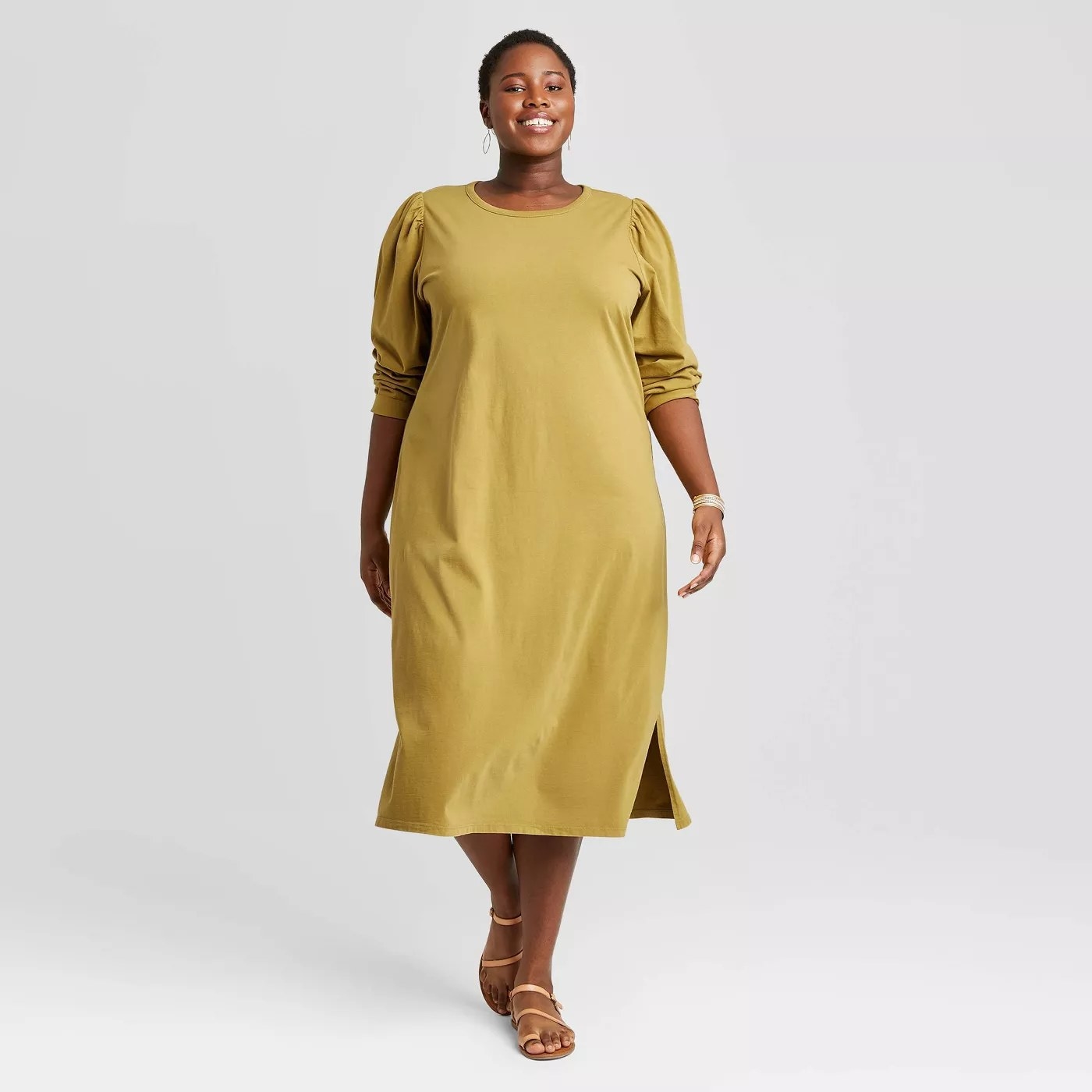 A mustard long sleeve shirt dress with puff sleeves paired with sandals.