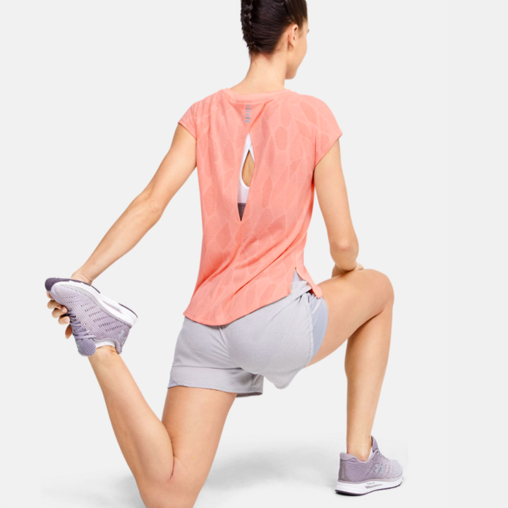 a model wearing the shirt in peach with a keyhole detail in the back