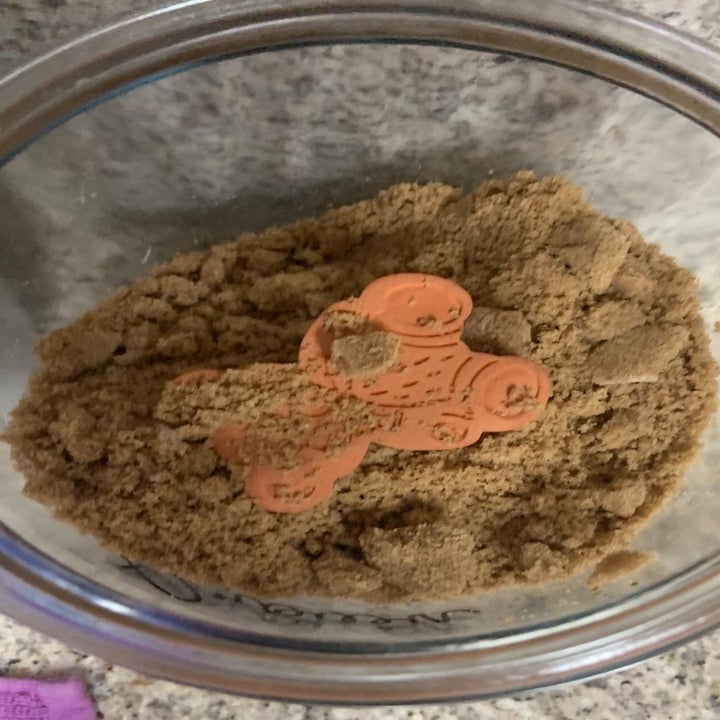 A reviewer photo of the clay bear inside a jar of soft brown sugar 