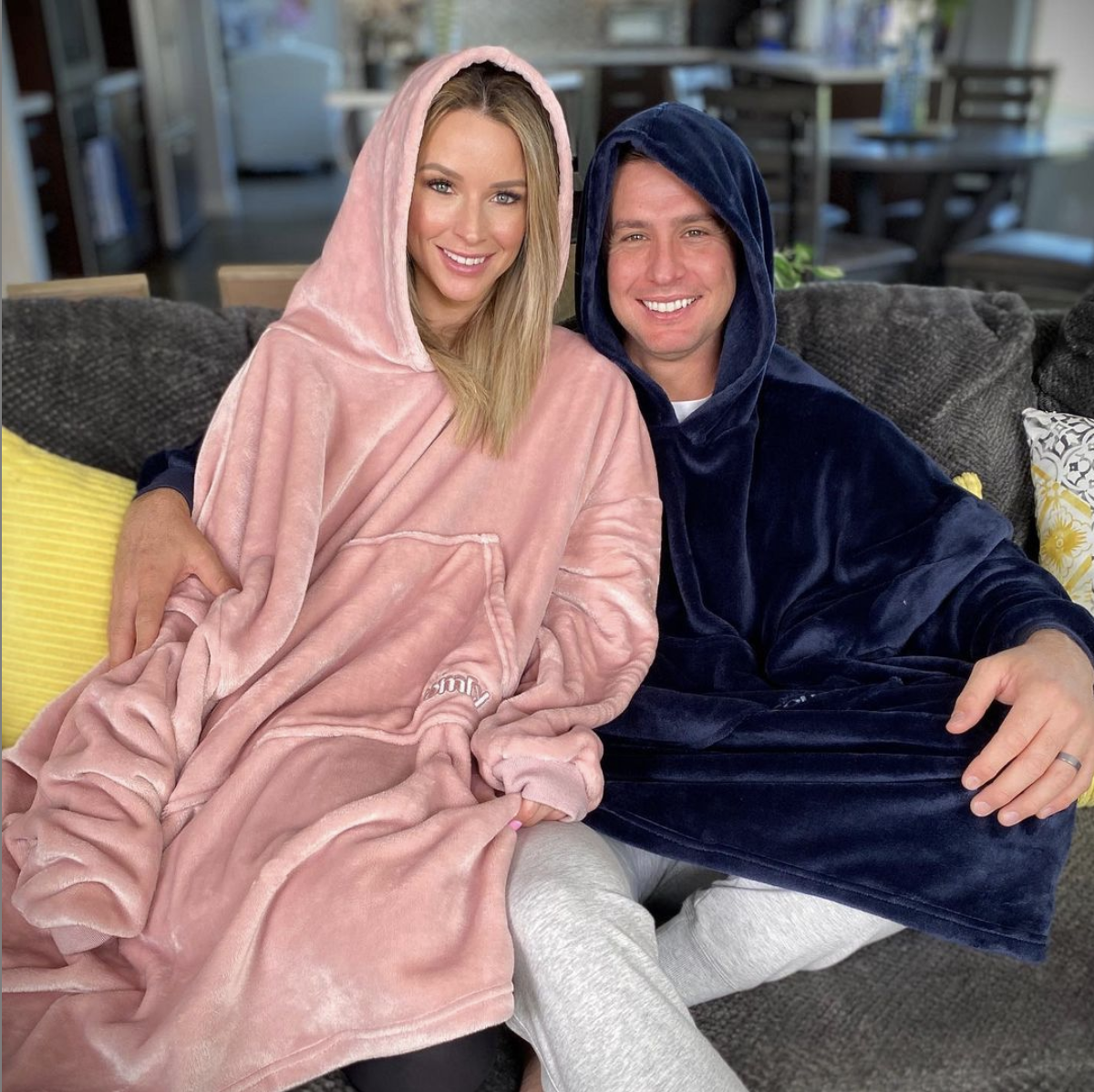 two people sitting together wearing the comfy wearable blanket