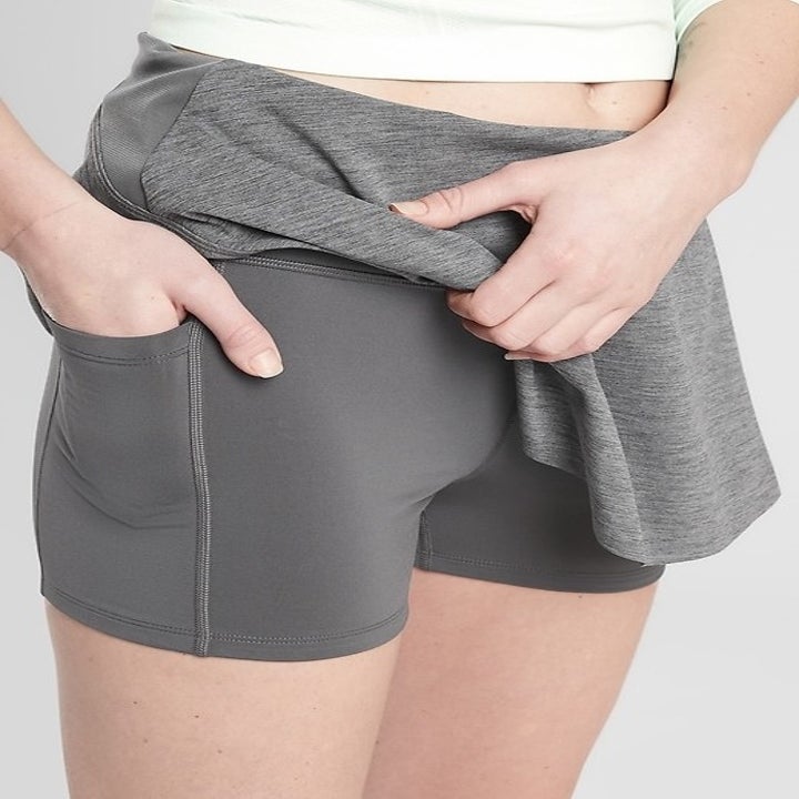 A model putting their hand in the skort's pocket