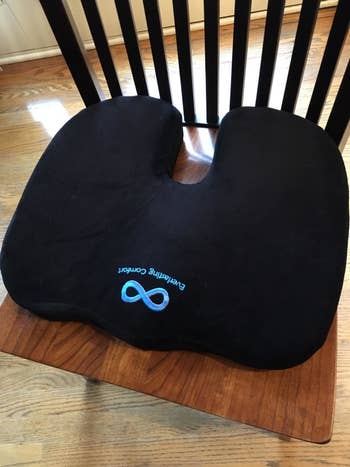 A reviewer's top view of the cushion used on a wooden dining chair
