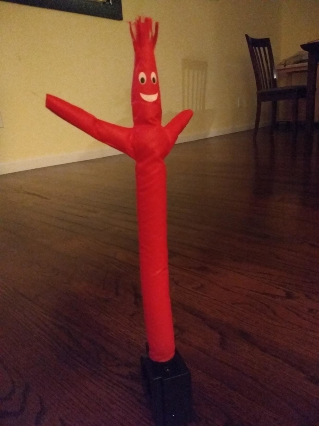 the inflatable tube guy displayed upright on the floor of someone&#x27;s home
