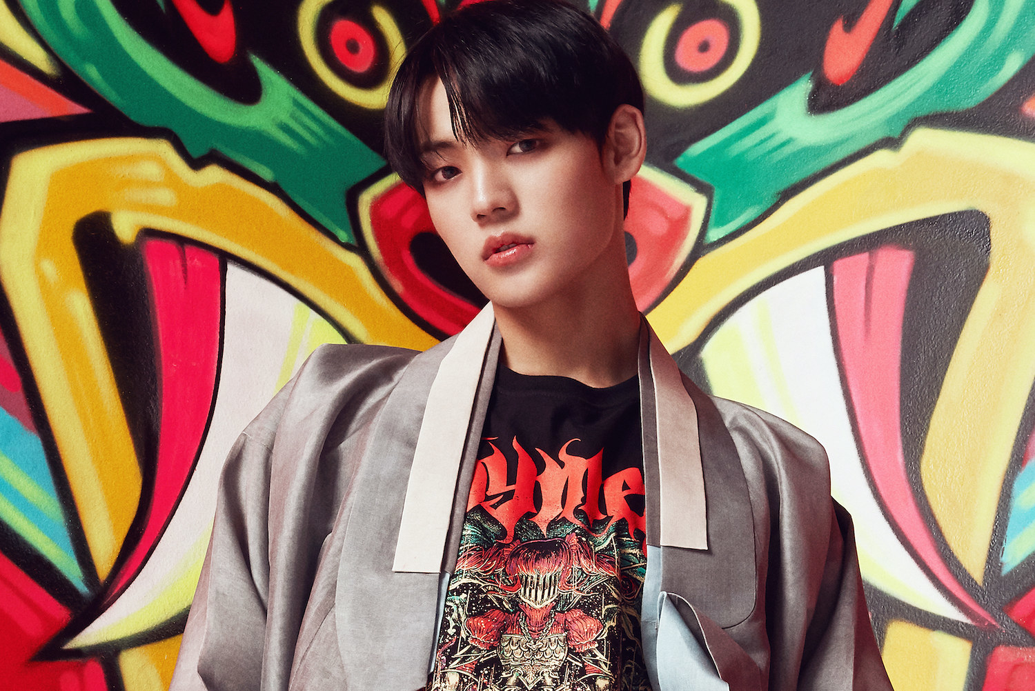Chan wears a robe and a rock band t-shirt
