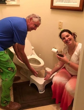 A different reviewer's photo of two people showing off their Squatty Potty