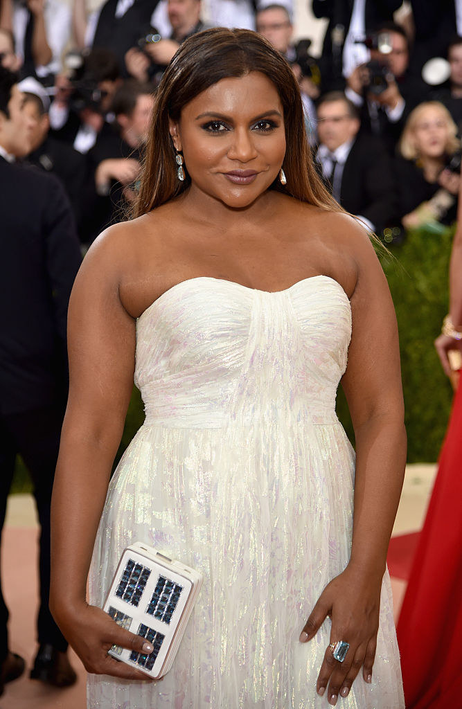 Mindy grinning in a dress with a sweetheart neckline