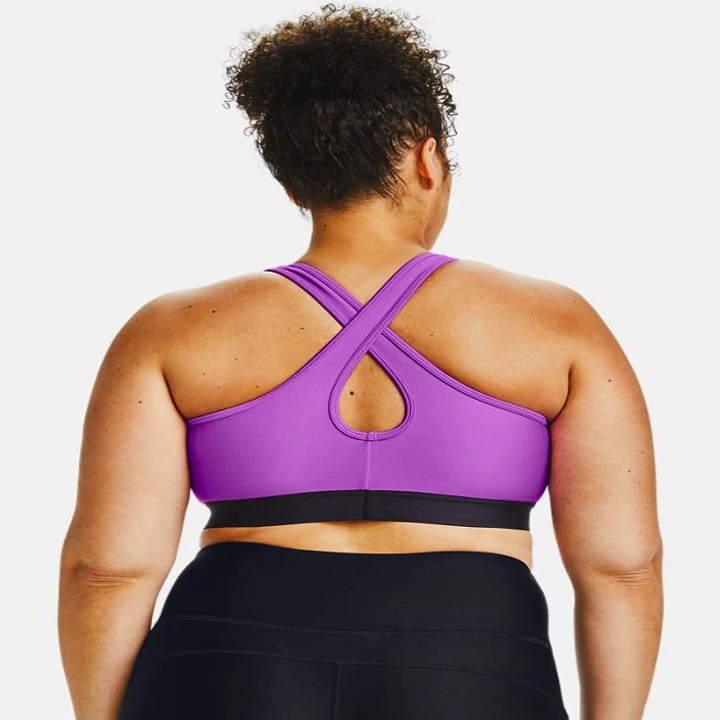the same model showing the cross-back of the bra in purple