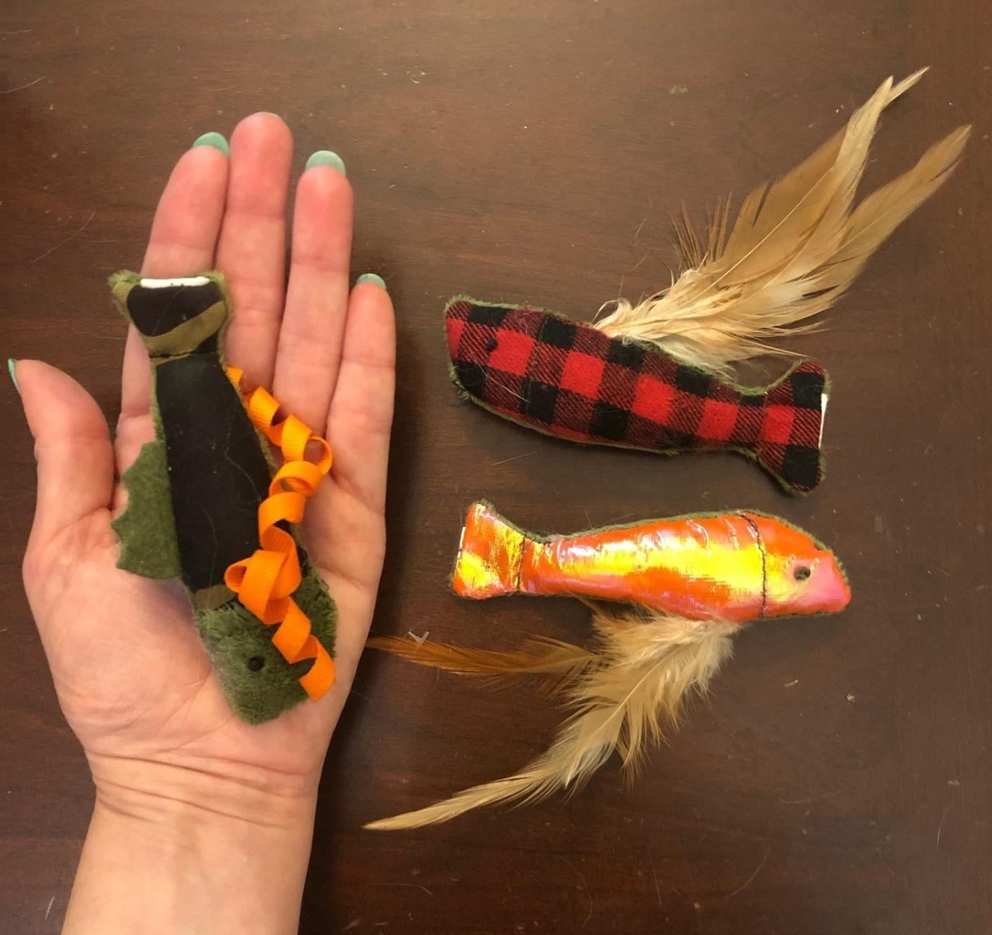 Three of the toys, with one placed on an open palm