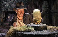 Indiana Jones stares at the golden idol he just found
