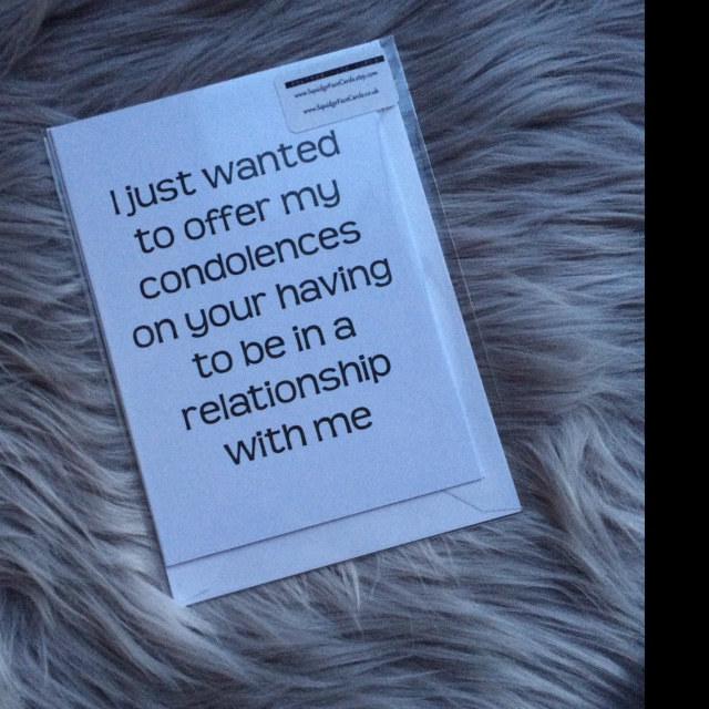 A white card with black type that reads "I just wanted to offer my condolences on your having to be in a relationship with me"