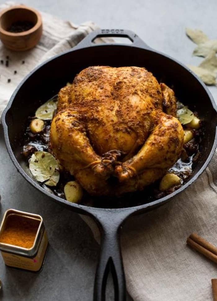 cast iron skillet with a roasted chicken
