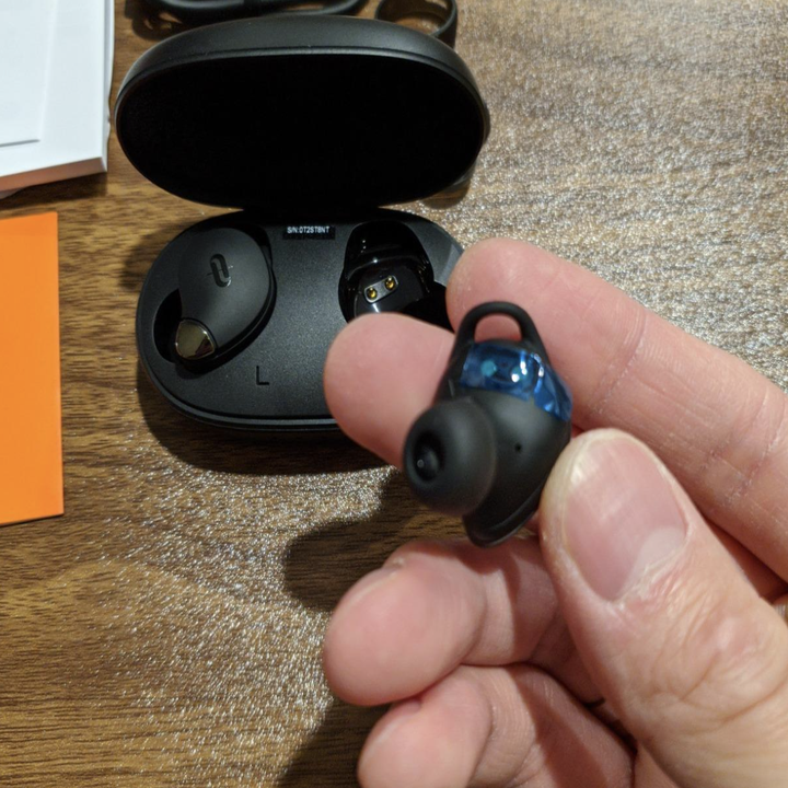 reviewer taking black taotronics headphones out of its charging case