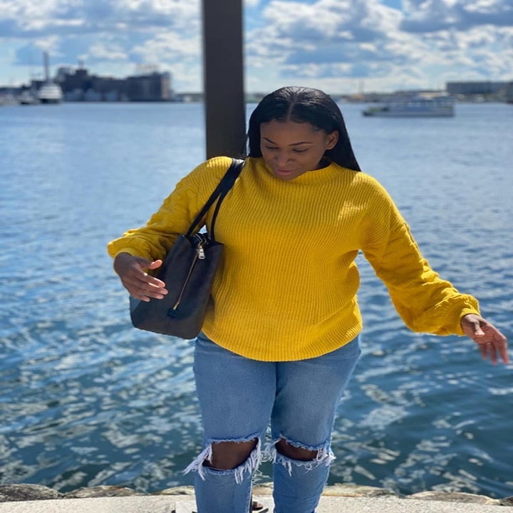 A different reviewer wearing the sweater in bright yellow