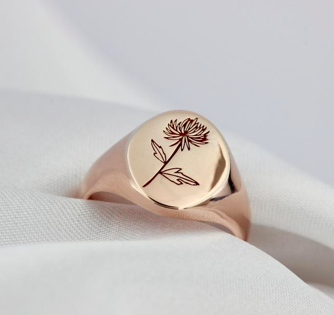 A close up of a signet ring stamped with a flower