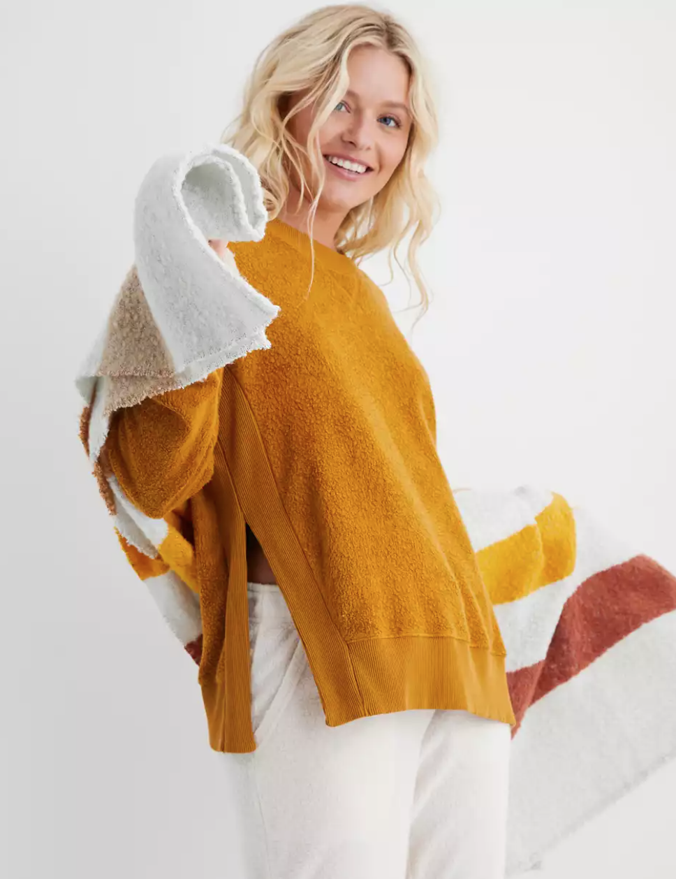 a model in a mustard yellow plush pullover