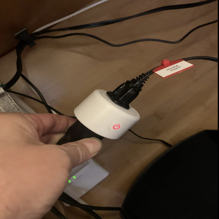 reviewer holding the smart plug 